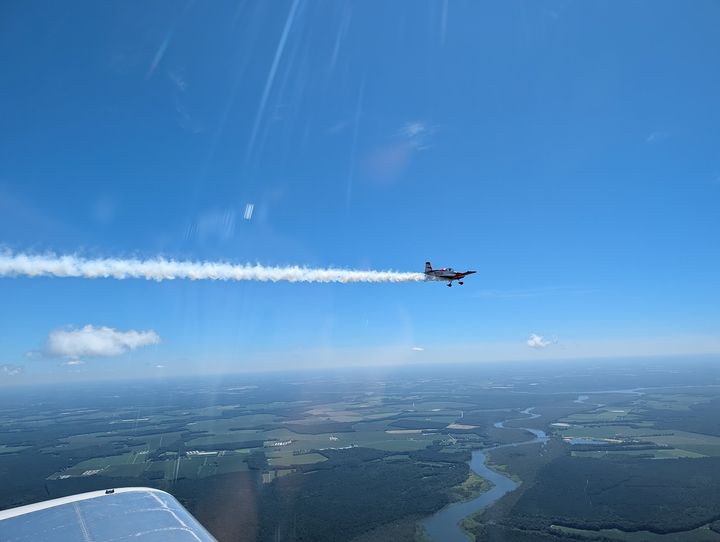 An RV flying in the distance with a long white smoke trail behind it.